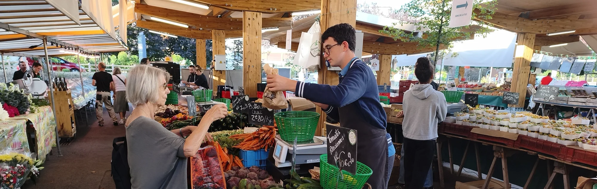 Lors du marché de Bailly, une citoyenne achète des légumes